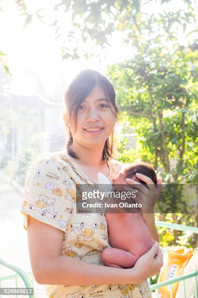 asian woman carrying her baby under sunlight - hot filipina women stock pictures, royalty-free photos & images