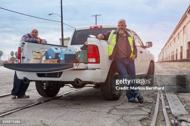 construction workers are waiting at their pick-up truck - pick up truck stock-fotos und bilder