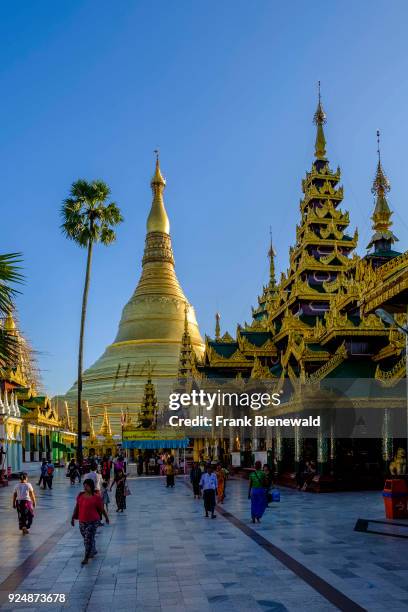 People are walking around the golden Shwedagon pagoda, the most sacred pagoda of Myanmar, located on a hill in the centre of town.