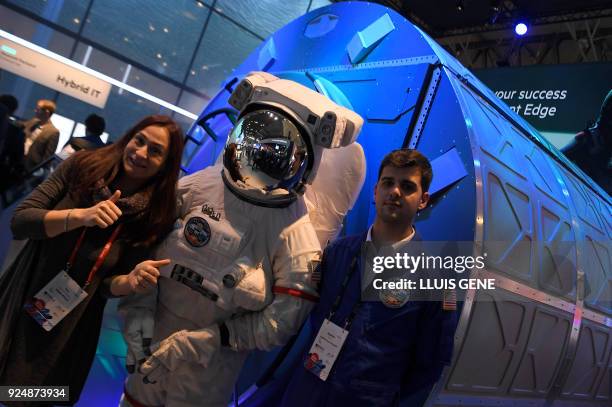 Host pose at the Hewlett Packard stand with an astronoaut mannequin in front of a copy of a prototype computer made for planet Mars at the Mobile...