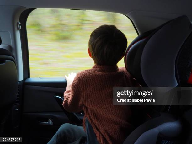 child sat in a car looking out of the window during road trip - car back view bildbanksfoton och bilder