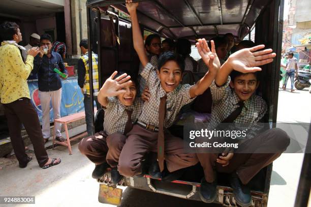 Ajmer schoolboys waving from a vehicle. India.