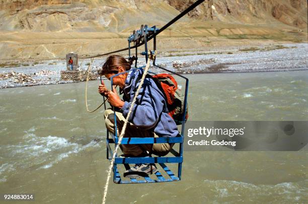 Crossing a river in a gondola. India.