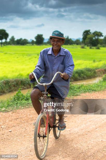 Khmer riding a bicycle on a country road. Cambodia.