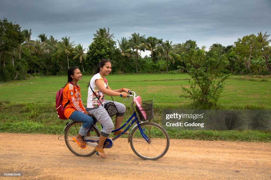 Schoolgirls on a bike. Battambang.  Cambodia.