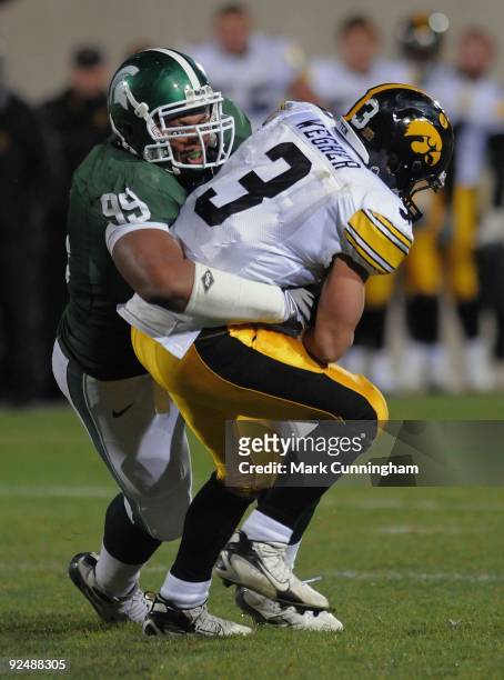 Brandon Wegher of the Iowa Hawkeyes is tackled by Jerel Worthy of the Michigan State Spartans at Spartan Stadium on October 24, 2009 in East Lansing,...