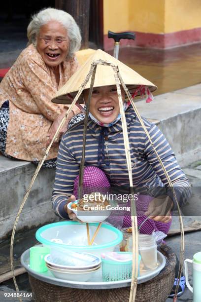 Vietnamese woman selling food in the street. Hoi An. Vietnam.