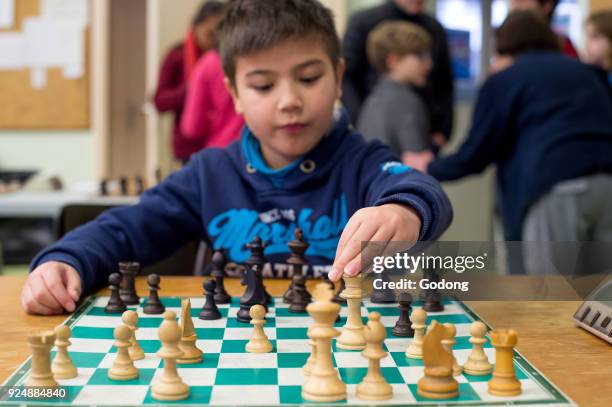 Boy playing chess. France.