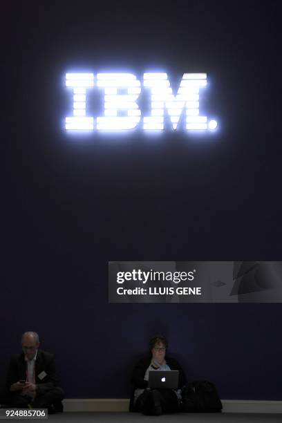 Woman checks her labtop under the IBM sign at the Mobile World Congress , the world's biggest mobile fair, on February 27, 2018 in Barcelona. The...