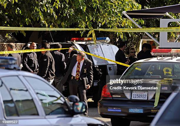 Los Angeles Police Department officers and investigators gather at a command post where a gunman shot and wounded two men in the underground parking...