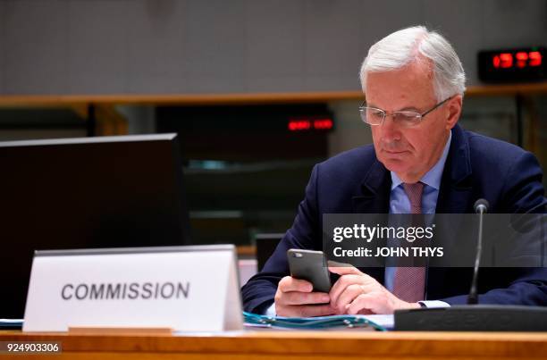 European Union Chief Negotiator in charge of Brexit negotiations, Michel Barnier uses his mobile during a General affairs council debate on the...