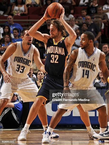 Josh McRoberts of the Indiana Pacers looks to pass between Ryan Anderson and Jameer Nelson of the Orlando Magic during a pre-season game on October...