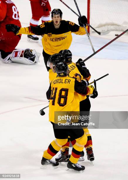 Jonas Muller of Germany celebrates his goal with teammates and Frank Mauer during the Men's Ice Hockey Gold Medal match between Germany and Olympic...