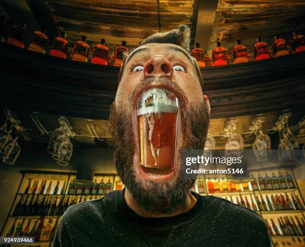 glas bier im mund des mannes in bar - whisky bar stock-fotos und bilder