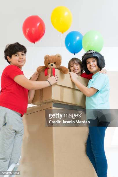 happy brothers playing with balloons and carton box - happy arab family on travel stockfoto's en -beelden