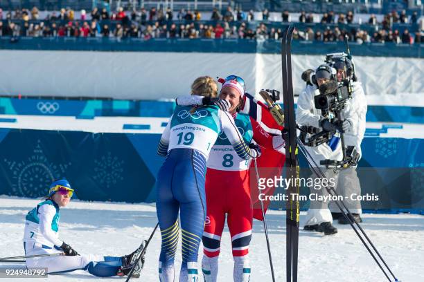 Gold medal winner Marit Bjoergen of Norway congratulates bronze medal winner Stina Nilsson from Sweden watched by silver medal winner Krista...