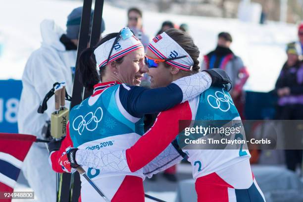 Gold medal winner Marit Bjoergen of Norway commiserates with team mate Ingvild Flugstad Oestberg of Norway who finished out of the medals during the...