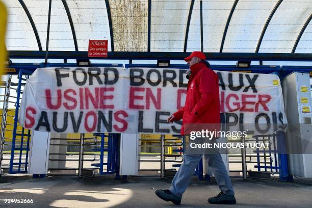 Workers gather at the entrance to US car maker Ford Aquitaine Industries plant in Blanquefort near Bordeaux, southwestern France as directors of Ford...