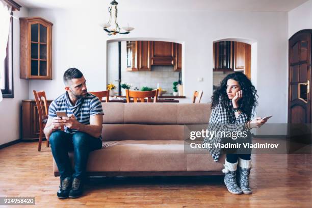 echtpaar met relatie-problemen zittend op de bank thuis - sad woman divorce stockfoto's en -beelden