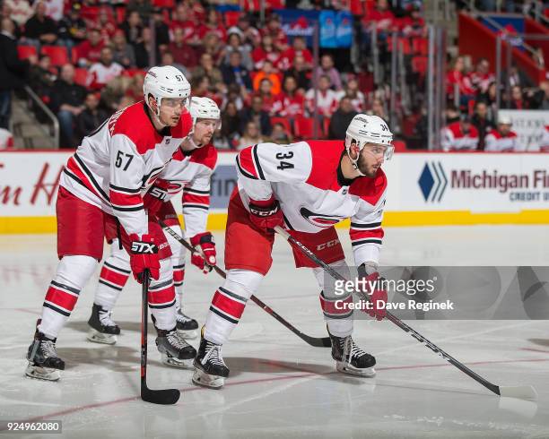Phil Di Giuseppe and Trevor van Riemsdyk of the Carolina Hurricanes gets set for the face-off against the Detroit Red Wings during an NHL game at...