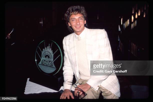 Portrait of American Jazz and Pop musician Barry Manilow poses with an award during a press conference at the Rainbow Grill, New York, New York,...