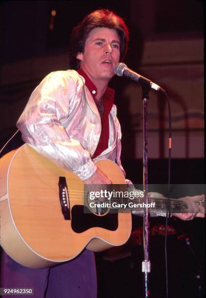 American Rock musician Ricky Nelson plays acoustic guitar as he performs onstage at the Ritz, New York, New York, February 24, 1981.