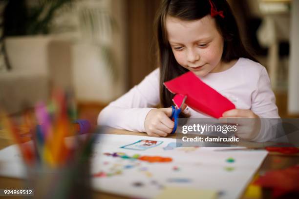 cute little girl cutting colorful paper at home - child craft stock pictures, royalty-free photos & images