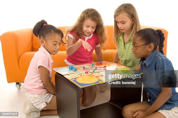 group of 4 young children sat around playing board games - board games stock pictures, royalty-free photos & images