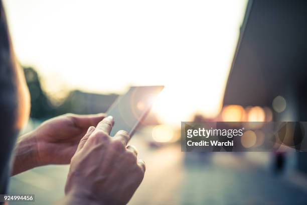 mujer usando su teléfono móvil en la calle - con mucha luz fotografías e imágenes de stock