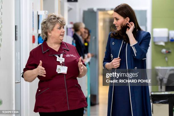 Britain's Catherine, Duchess of Cambridge, walks with director of nursing Janet Powell as she visits the children's "Snow leopard" ward during a...