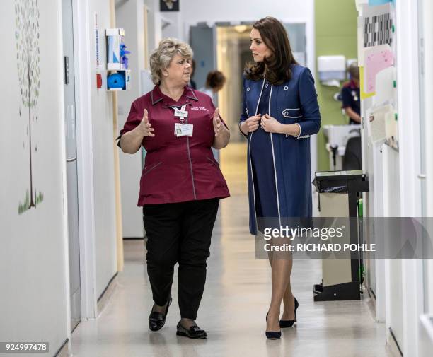 Britain's Catherine, Duchess of Cambridge, walks with director of nursing Janet Powell as she visits the children's "Snow leopard" ward during a...