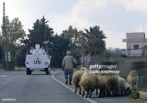 Lebanese shepherd walks past soldiers form the Italian contingent in the UNIFIL as they patrol the blue line area in Lebanon's southern border town...
