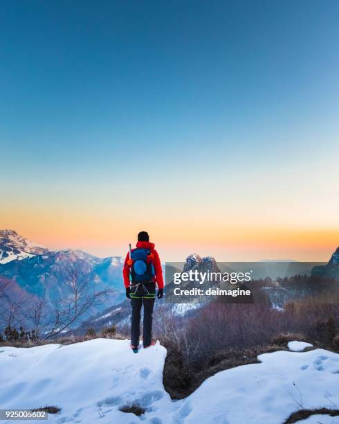 wanderer auf den bergen anzeigen bei sonnenaufgang - man standing in the snow stock-fotos und bilder