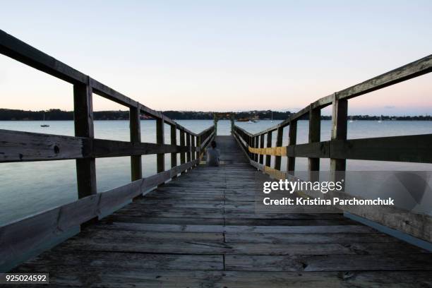 sitting on wairangi wharf at blue hour - herne bay stock pictures, royalty-free photos & images