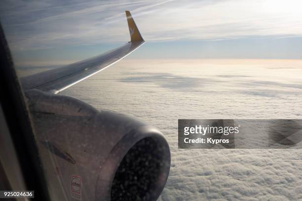 europe, germany, 2018: view of passenger jet aircraft window view of engine and clouds - commercieel vliegtuig deur stockfoto's en -beelden