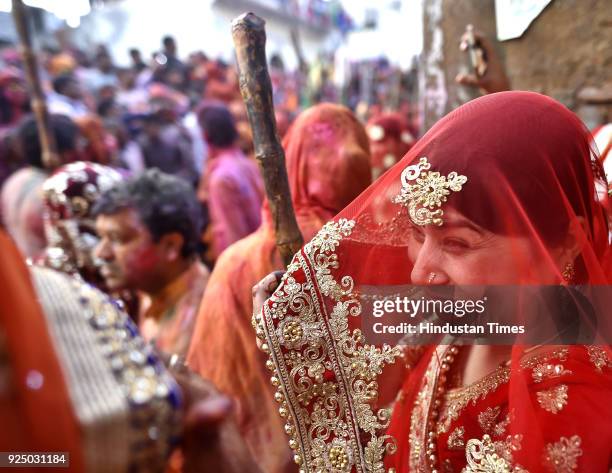 People smear themselves with colours during the Lathmar Holi festival at the Nandji Temple on February 25, 2018 in Nandgaon, India. The women of...