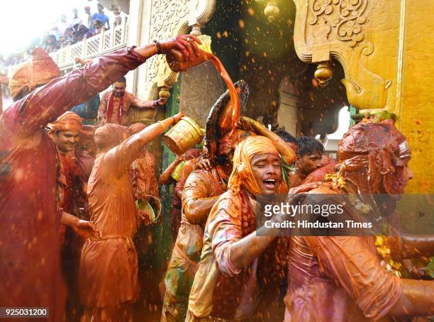 People smear themselves with colours during the Lathmar Holi festival at the Nandji Temple on February 25, 2018 in Nandgaon, India. The women of...