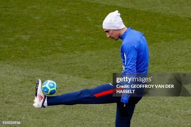 Paris Saint-Germain's Argentinian forward Angel Di Maria plays with a miniature ball during a training session at the Camp des Loges training centre...