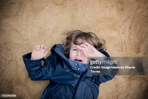 3 year old crying laying on the floor - schmerzfrei stock-fotos und bilder