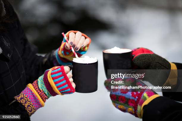 winter scene of hot cocoa and girls hands in mittens - woman hands in mittens stock-fotos und bilder