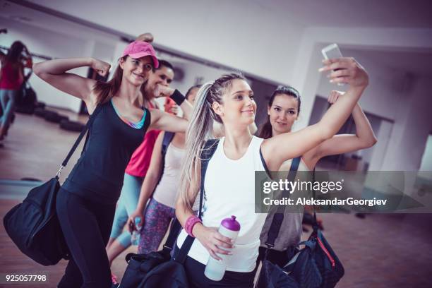 happy female group taking selfie in gym after exercise - group of people flexing biceps stock pictures, royalty-free photos & images