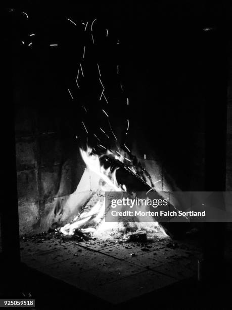 black and white shot of a glowing fire in a log burning stove in norway, summertime - open fire stock pictures, royalty-free photos & images