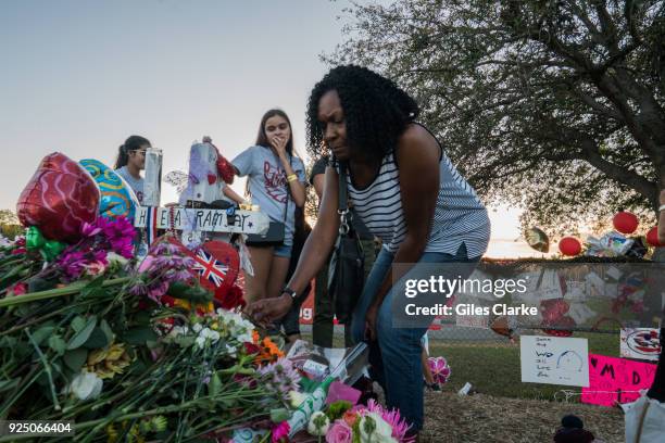 Anne Ramsey places a rose on her daughters' memorial site outside the Marjory Stoneman Douglas High School. Anne moved from the UK to Florida in...