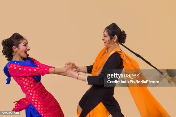 two sikh women playing kikli game - lohri festival imagens e fotografias de stock