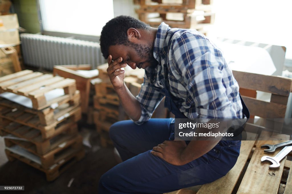 Exhausted African employee in warehouse