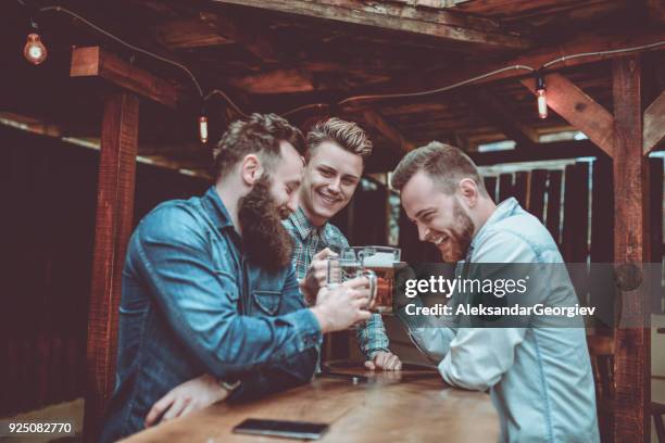 group of smiling friends celebrating with beer - honour board stock pictures, royalty-free photos & images