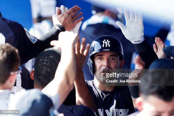 Danny Espinosa of the New York Yankees celebrates with teammates in the dugout after hitting a solo home run in the fourth inning of a Grapefruit...