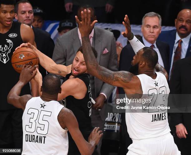 Kevin Durant and LeBron James of Team Lebron defend Stephen Curry during the final seconds of the fourth quarter, preventing him from making a shot...