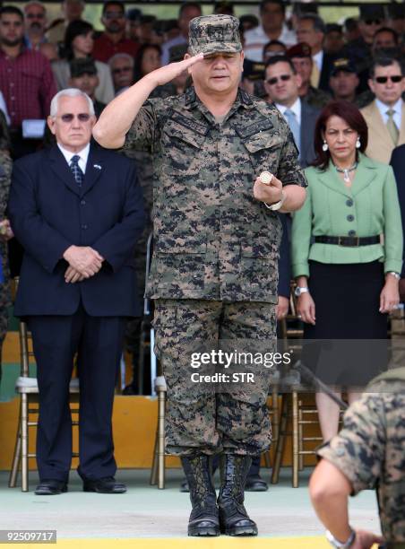 The Chief of the Honduran Armed Forces, General Romeo Vasquez , salutes the troops at Campo Marte as Honduran de facto leader Roberto Micheletti...