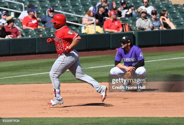 Rene Rivera of the Los Angeles Angels of Anaheim rounds the bases after hitting a solo home run in the fourth inning as Nolan Arenado of the Colorado...